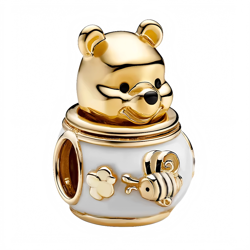Ajoutez une dose de tendresse à votre collection avec ce charm unique, incarnant Winnie l’Ourson dans sa posture préférée : près d’un pot de miel débordant de douceur. Retrouvez toute la magie des contes Disney à travers cette création lumineuse, idéale pour accompagner vos plus beaux instants gourmands et féeriques.
Ce charm séduit par ses détails minutieux : la silhouette chaleureuse de Winnie coiffant un pot de miel nacré, décoré d’une abeille stylisée et d’une fleur délicate. Chaque reflet doré rappell