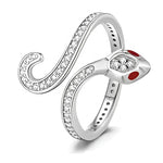 Cette bague en argent 925 dessine la silhouette d’un serpent qui s’enroule autour du doigt, avec un anneau fin prolongé par une longue queue ouverte et courbée, entièrement sertie de petits cristaux scintillants. La tête du serpent, mise en avant, est ornée d’un cristal central facetté et de deux touches d’émail rouge pour figurer les yeux, donnant un look à la fois élégant et mystérieux.

Caractéristiques :
Matière : Argent 925/1000 (sterling silver) avec incrustation de cristaux clairs et détails d’émail 
