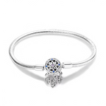 Ce bracelet en argent 925 met en valeur un fermoir inspiré d’un attrape-rêves, décoré d’un motif floral central et de cristaux bleus et violets, d’où pendent trois fines plumes gravées.
Il apporte une touche bohème et spirituelle au poignet et peut se porter seul ou avec des charms de type européen pour composer un univers rêveur et protecteur.