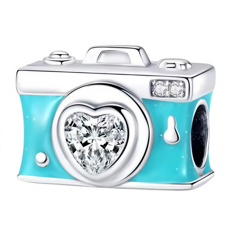 Ce charm vintage ludique reproduit un appareil photo rectangulaire turquoise brillant, lentille ronde ornée d'un cœur scintillant de cristaux transparents, poignée supérieure et viseur latéral détaillés. Deux cristaux blancs latéraux ajoutent éclat au boîtier argenté poli, avec suspension intégrée. Symbole de souvenirs précieux et créativité pétillante, il dynamise les bracelets d'un esprit aventurier joyeux.

Caractéristiques

Matière : Argent 925 avec émail turquoise et cristaux transparents blancs.
Desig