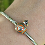 Ajoutez une touche d'aventure galactique à votre collection avec ce charm représentant BB-8, le droïde sphérique adoré de Star Wars. Conçu en argent sterling S925, ce charm capture avec précision les détails distinctifs et le design adorable de BB-8, apportant une note de joie et d'enthousiasme à vos bracelets.