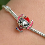 Célébrez la magie des fêtes avec ce charm adorable représentant bébé Stitch dans une tenue festive de Noël. Réalisé en Argent 925 (S925), ce charm met en scène Stitch portant un bonnet rouge chaleureux et une veste rouge éclatante, prêt à répandre la joie et la bonne humeur. Une pièce pleine de douceur et d’esprit festif, parfaite pour illuminer vos bracelets ou colliers durant la saison hivernale.