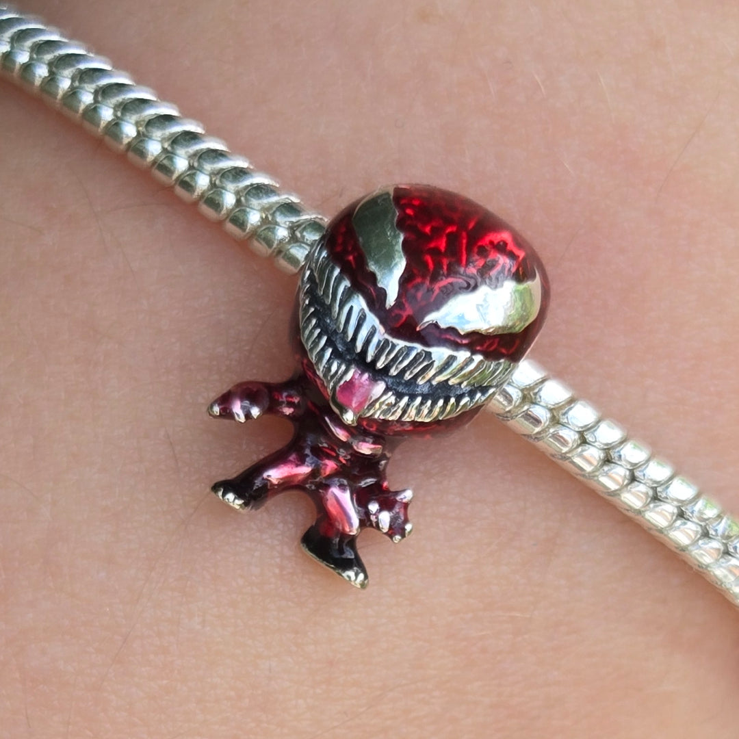 Remportez l’attention avec ce charm impressionnant à l’effigie de Carnage (Univers Vénom), l’antagoniste culte de l’univers Marvel. Sculpté avec précision, ce bijou affiche son visage déformé, ses crocs acérés et sa langue redoutable, incarnant toute la puissance et la folie du symbiote. Parfait pour les fans de super-héros et les collectionneurs à la recherche d’un accessoire original et audacieux pour leur bracelet à charms !

La couleur rouge métallique, les finitions argentées et les détails effrayants 