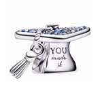 Célèbre une grande victoire avec ce charm en argent sterling 925 en forme de chapeau de diplôme, délicatement gravé de l’inscription “You Made It”. Symbole parfait de réussite et de fierté, ce bijou capture l’émotion d’un accomplissement important avec élégance et simplicité. Une pièce inspirante à offrir ou à porter pour marquer un moment inoubliable.

Caractéristiques :

- Matière : Argent 925.
- Design : Chapeau de diplôme détaillé avec inscription “You Made It”, finition brillante et élégante.
- Dimensi