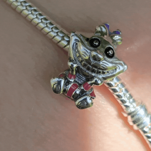 Ajoutez une touche d'espièglerie à votre collection avec ce Charm - Chat du Cheshire, en argent sterling S925. Inspiré du célèbre personnage d'Alice au Pays des Merveilles, ce charm capture parfaitement le sourire mystérieux et le regard malicieux du Chat du Cheshire, toujours prêt à semer le doute et à guider Alice à sa manière énigmatique. Idéal pour les fans de Disney et des contes fantastiques, ce charm apportera une aura magique et pleine de mystère à votre bracelet.