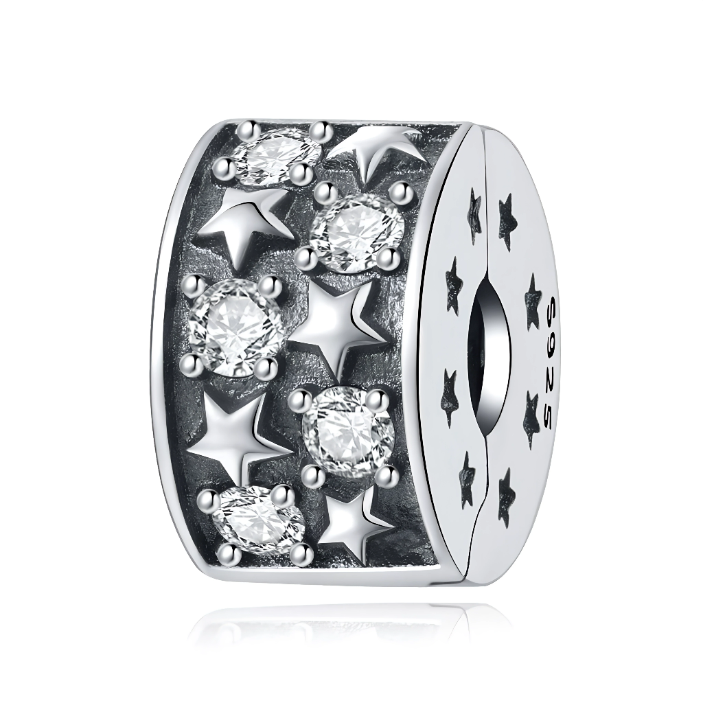 Ce charm clip en argent 925 est orné d’un motif en relief mêlant petites étoiles polies et rangées de cristaux ronds transparents, créant un effet de ciel nocturne scintillant. Les côtés sont décorés de mini étoiles gravées, et le système de clip permet de le fixer solidement sur le bracelet pour maintenir les autres charms en place.

Caractéristiques :

-Matière : Argent 925 avec cristaux transparents.
-Design : Clip cylindrique texturé, étoiles en relief et cristaux sertis griffes.
-Coloris : Argent brill