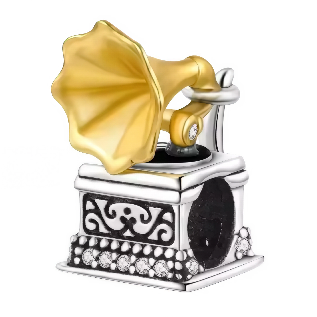 Ce charm reproduit l’élégance d’un gramophone ancien : pavillon doré en forme de corolle, bras de lecture délicatement ciselé et caisse décorée de motifs baroques. La base sertie de micro‑cristaux crée un scintillement subtil, tandis que la patine sombre souligne les reliefs et l’esprit authentique. Une pièce parfaite pour un bracelet à thème musique, vintage ou collection d’objets iconiques.