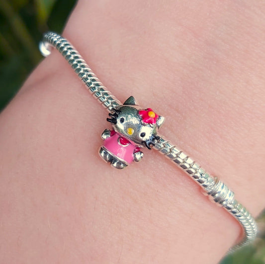 Apportez une touche adorable et emblématique à votre collection avec ce charm représentant Hello Kitty. Symbole de douceur et d'élégance, ce charm en argent 925 capture le célèbre visage de Hello Kitty avec son nœud distinctif. Parfait pour les fans de ce personnage intemporel, ce bijou ajoutera une touche mignonne et raffinée à votre bracelet ou collier.