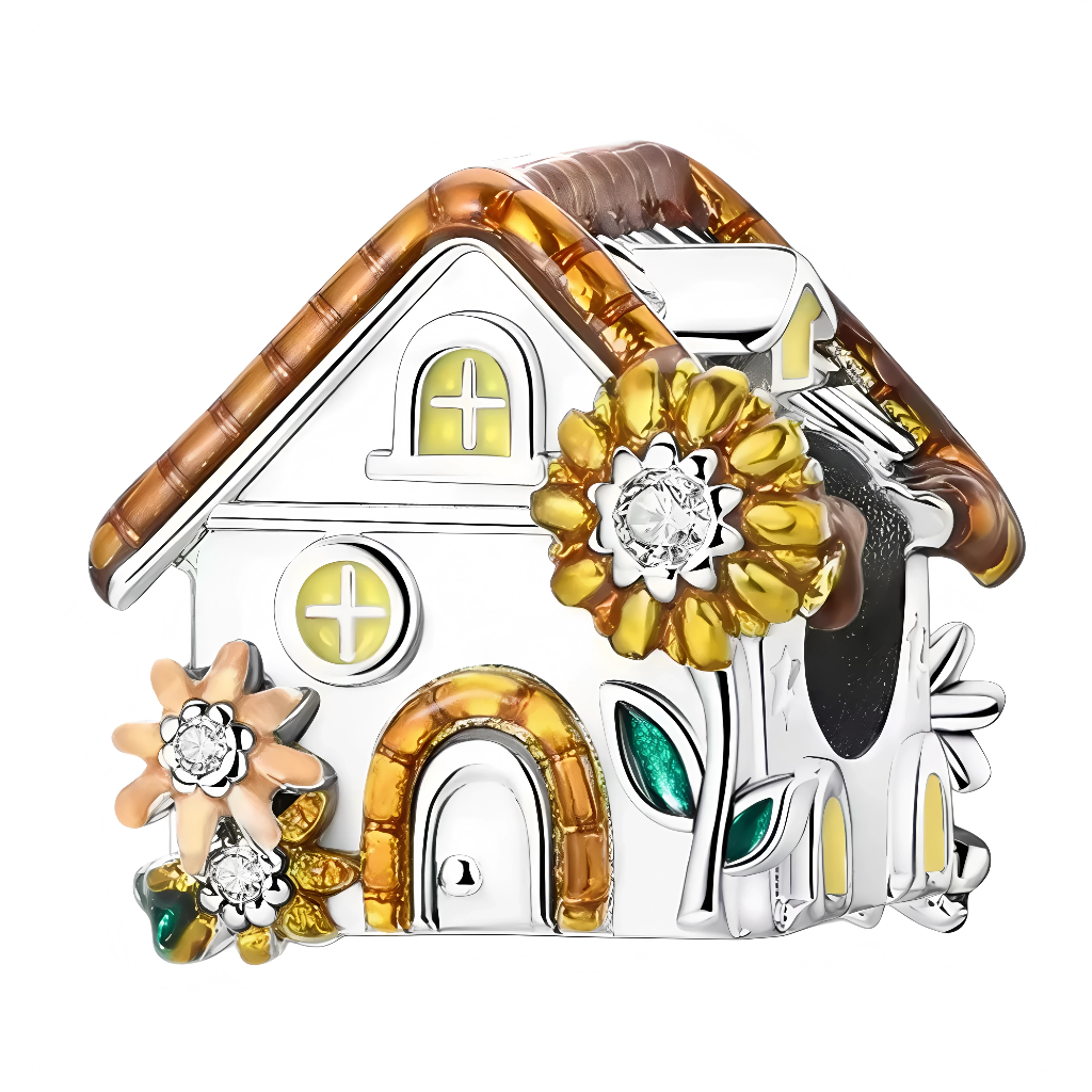 Ce charm célèbre la douceur des fins de journée d’automne. La petite maison arbore un toit émaillé miel, des fenêtres jaune doux et une porte cintrée assortie. En façade, un grand tournesol serti d’un cristal clair rayonne, accompagné de feuilles vertes et de petites fleurs, comme un jardin lumineux. Idéal pour un thème cocooning, nature ou souvenirs de campagne à la saison des couleurs.
