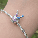 Le Charm Manège Donald et Daisy capture un moment enchanteur de Donald et Daisy profitant d’un tour de manège magique. Ce charm est un clin d'œil à l'univers ludique de Disney, parfait pour les collectionneurs et les amateurs de l'univers de Mickey et ses amis.
