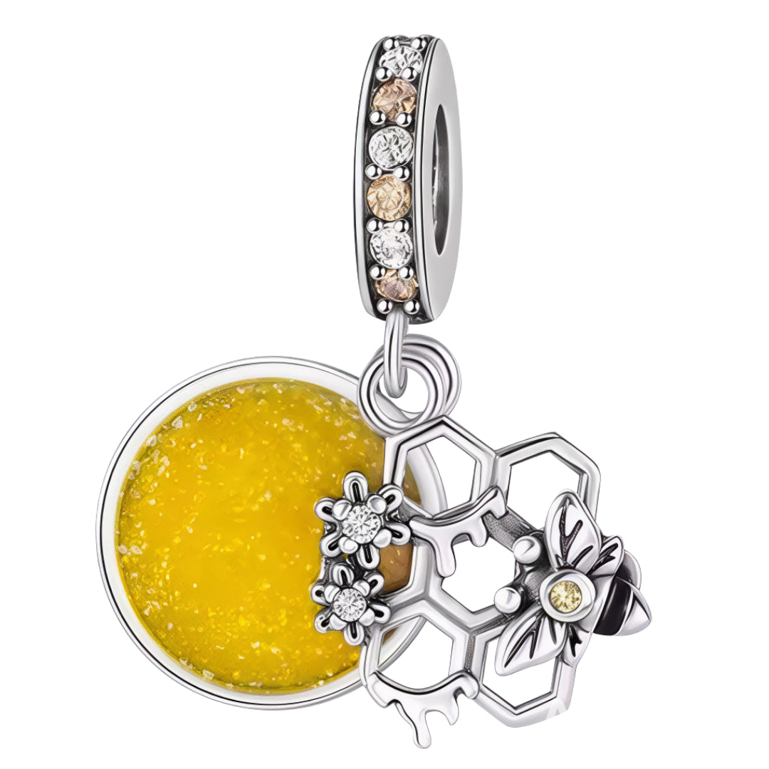 Ce charm exquis célèbre le monde des abeilles avec un pendentif double : un disque émaillé jaune évoquant une goutte de miel et une structure en alvéoles d’argent ornée de fleurs de cristal et d’une abeille stylisée. La bélière pavée de cristaux champagne et transparents apporte encore plus d’éclat à l’ensemble. Symbole de nature, de douceur et de travail collectif, ce bijou s’intègre parfaitement aux bracelets à charms européens pour une touche lumineuse et tendance.

Caractéristiques
Matière : Argent 925,