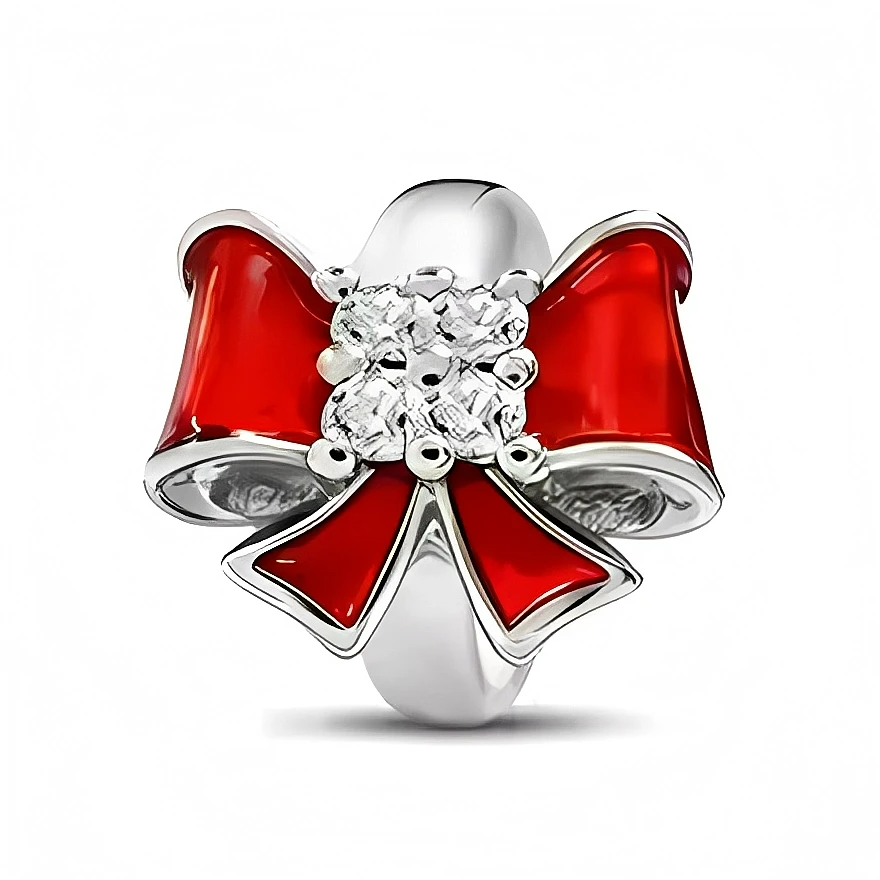 Ce charm en argent 925 représente un grand nœud de cadeau rouge, aux rubans laqués façon émail pour un effet brillant et gourmand. En son centre, un bouquet de petites pierres claires type cristaux capte la lumière et apporte une touche précieuse parfaite pour les fêtes.

Caractéristiques :

- Matière : Argent 925 avec émail rouge et pierres synthétiques transparentes.
- Design : Large nœud de cadeau aux pans croisés, agrémenté d’un cœur de cristaux.
- Coloris : Argent lumineux, rouge intense, éclats transp