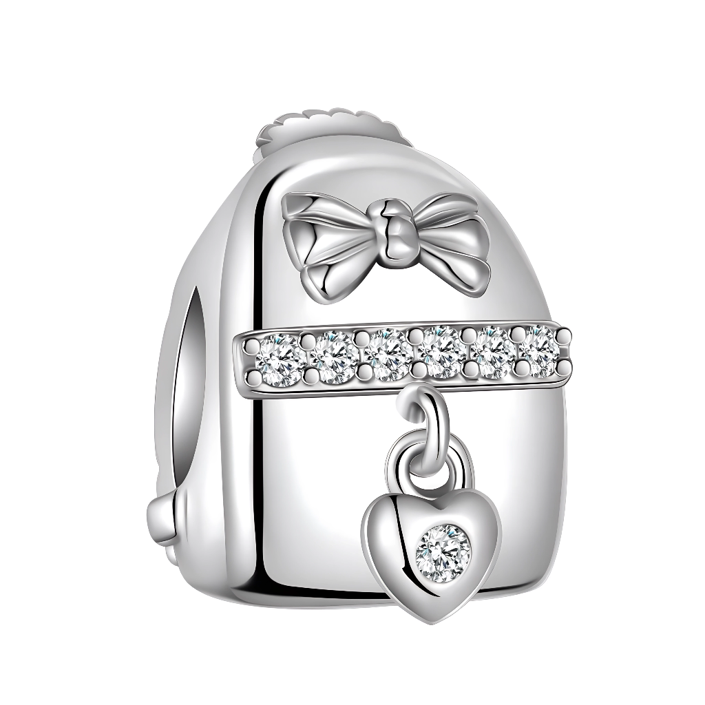 Le charm reprend les lignes d’un sac à dos lisse en argent, orné sur le haut d’un nœud délicat qui lui donne un look féminin et élégant. Une rangée de zircons scintillants traverse le centre comme une lanière brillante, d’où pend un petit cœur serti d’une pierre claire, rappelant les souvenirs précieux que l’on emporte partout avec soi. Ce bijou au design épuré s’associe aussi bien à un thème voyage qu’à un thème scolaire, et fait un cadeau symbolique pour une étudiante, une globe‑trotteuse ou toute personn
