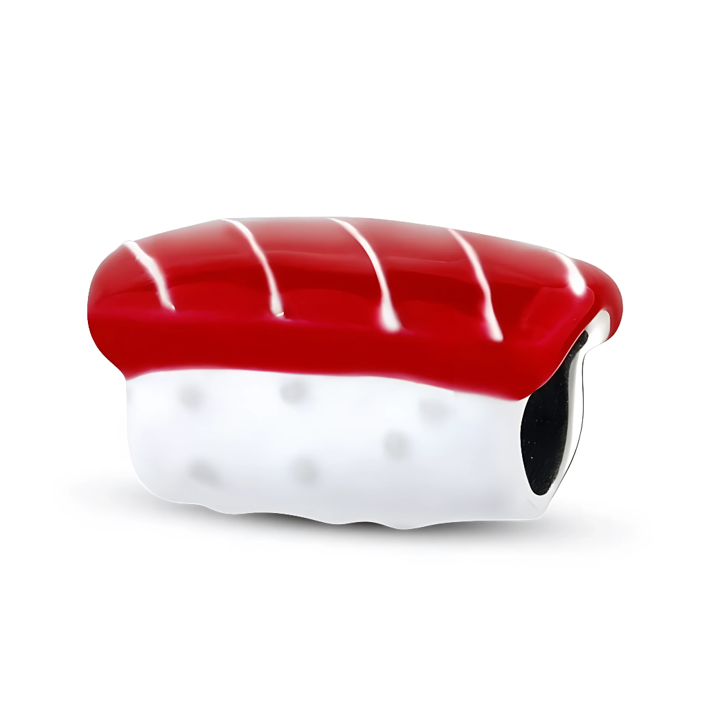 Le corps du charm, en argent 925 recouvert d’émail, forme une petite pièce de sushi allongée, la partie riz étant légèrement bombée et ponctuée de discrets détails pour suggérer les grains. La tranche de thon rouge brillant apporte une touche pop et gourmande, idéale pour les amateurs de cuisine japonaise ou pour un bracelet à thème « food lover ».