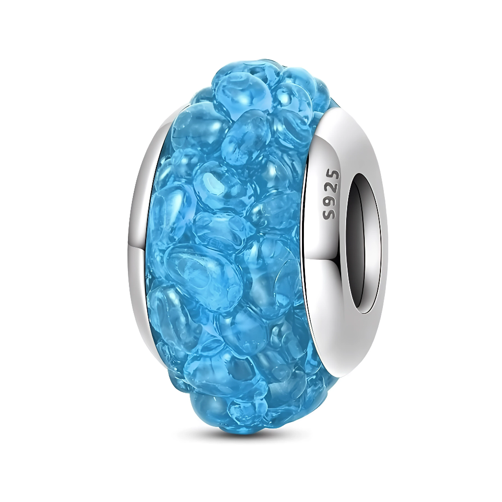 Ce charm en&nbsp;verre&nbsp;de Murano bleu océan présente une texture en relief façon bulles d’eau sur toute la surface, encadrée par des bords lisses en argent 925 gravés “S925”