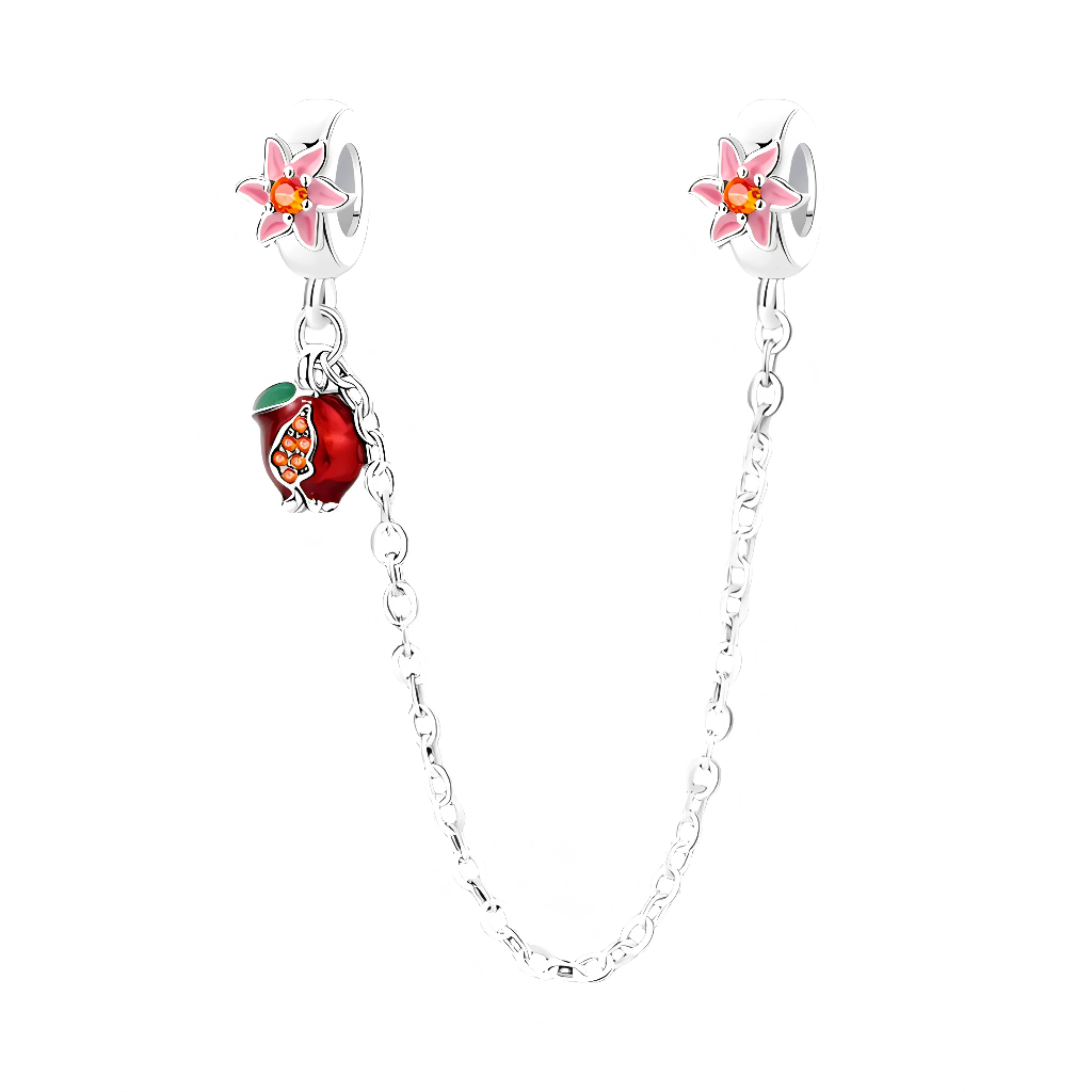 Cette chaîne de sécurité en argent 925 apporte une note fraîche et fruitée au bracelet, grâce à ses deux bélières ornées de petites fleurs roses émaillées au cœur jaune lumineux. D’un côté, un pendentif grenade rouge profond, ouvert sur des graines pavées de cristaux orangés et coiffé d’une petite feuille verte, apporte une touche de couleur gourmande qui balance délicatement le long de la chaîne.