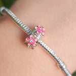 Apportez une touche florale et élégante à votre bracelet avec le Charm Clips - Espaceur Marguerite Rose en argent sterling S925. Ce charm raffiné est orné de petites marguerites roses délicates, symbolisant la beauté et la joie. Parfait pour les amateurs de fleurs et de designs subtils, cet espaceur permet de maintenir vos charms en place tout en ajoutant une note printanière et colorée à votre collection.