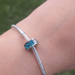Apportez une touche de couleur vibrante à votre collection avec le Charm Clips - Pavé Bleu-Vert. Ce charm en argent sterling S925 est orné d’une rangée de pavés scintillants dans des tons captivants de bleu et de vert, évoquant l’éclat des mers tropicales. Élégant et rafraîchissant, ce charm ajoute une touche de dynamisme et de sophistication à votre bracelet tout en maintenant vos charms en place avec style.