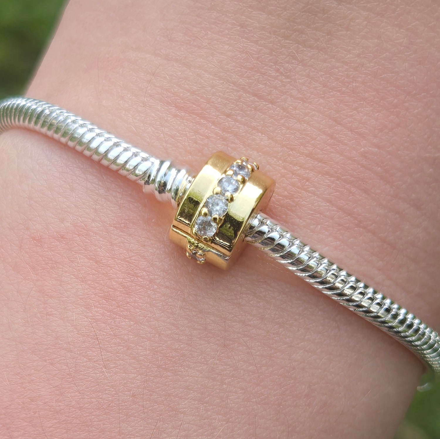 Ajoutez une touche de brillance subtile à votre collection avec le Charm Clips - Rangée Scintillante Incolore. Fabriqué en argent sterling S925, ce charm clip est orné de pierres cristallines incolores qui capturent et reflètent la lumière avec élégance. Son design raffiné et discret est parfait pour ajouter une lueur sophistiquée à votre bracelet tout en maintenant vos charms bien en place.