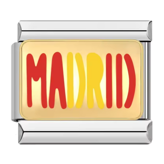 Ce charm italien en acier inoxydable argenté arbore l’inscription "Madrid" décorée aux couleurs vibrantes du drapeau espagnol, sur un fond élégant couleur or. Alliant robustesse et finesse des détails, ce charm apporte une touche moderne et chaleureuse à votre bracelet. Facile à fixer, il s’adapte parfaitement à nos bracelets composés de 17 maillons extensibles et réglables, convenant à toutes les tailles de poignet.