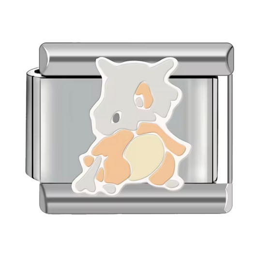 Ce charm italien représente Osselait, le Pokémon os emblématique connu pour sa robustesse et son allure unique. Confectionné en acier inoxydable argenté de haute qualité, il présente des détails précis et une finition brillante, parfaits pour les fans de l’univers Pokémon. Facile à fixer, il s’intègre parfaitement à nos bracelets composés de 17 maillons extensibles et réglables, adaptés à tous les poignets. Compatible avec tous nos charms italiens, ce bijou est idéal pour ajouter une touche audacieuse et or