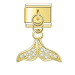 Ce charm italien pendentif en forme de queue de dauphin, finition dorée, symbolise la grâce et la liberté des océans. Fabriqué en acier inoxydable de haute qualité avec un placage doré élégant, il allie robustesse et finesse des détails pour un rendu raffiné et lumineux. Facile à fixer, il s’adapte parfaitement à nos bracelets composés de 17 maillons extensibles et réglables, convenant à toutes les tailles de poignet. Compatible avec tous nos charms italiens