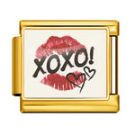Affichez une allure chic et mystérieuse avec ce charm italien en&nbsp;doré&nbsp;inspiré des codes du glamour et des messages secrets. Orné d’une trace de lèvre et du mot&nbsp;XOXO, il évoque les baisers, les rumeurs et l’élégance des univers les plus tendance. Un bijou raffiné et audacieux, parfait pour apporter une touche fashion, féminine et irrésistible à votre collection.

Caractéristiques :

- Matière : Doré.
- Thème : Glamour, amour, secrets, mode.
- Design : Trace de lèvre, inscription XOXO, style ch