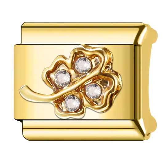 Ce charm italien doré, en forme de trèfle à 4 feuilles, est orné d’une pierre brillante délicatement incrustée dans chaque feuille. Fabriqué en acier inoxydable de haute qualité avec un revêtement doré élégant, il allie résistance et raffinement. Facile à fixer, il s’adapte parfaitement à nos bracelets composés de 17 maillons de charms, qui s’étendent et se contractent pour un ajustement idéal à votre poignet. Tous nos charms italiens sont compatibles entre eux, vous permettant de personnaliser votre bijou 