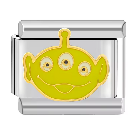 Ce charm italien amusant représente le visage souriant de l’Alien, personnage culte de Toy Story. Confectionné en acier inoxydable argenté de haute qualité, il séduit par ses détails précis et sa brillance durable. Facile à fixer, il se glisse parfaitement sur nos bracelets composés de 17 maillons extensibles et réglables, adaptés à tous les poignets. Compatible avec tous nos charms italiens, ce bijou est idéal pour apporter une touche ludique et originale à votre collection.