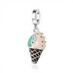 La bélière en argent 925 lisse laisse pendre un cornet façon gaufrette chocolat brune, surmonté d’une boule de glace bicolore crème et vert menthe, décorée de petites pépites colorées. Un fin bandeau pavé de zircons clairs souligne la séparation des saveurs, ajoutant une note scintillante à ce motif de glace très réaliste.