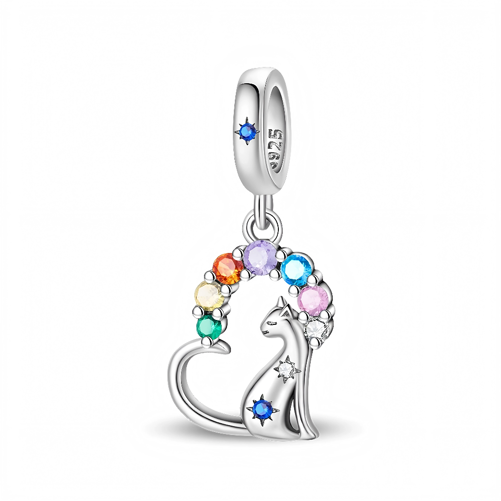 Le chat stylisé forme la base du pendentif, orné de deux étoiles scintillantes dont l’une accueille une gemme bleue au niveau du flanc. Au‑dessus, un demi‑cercle de pierres rondes dans les tons rouge, orange, jaune, vert, bleu, lilas et rose symbolise un arc‑en‑ciel de couleurs lumineuses, idéal pour les amoureux des chats et des bijoux colorés.