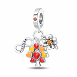 La bélière en argent 925 est sertie d’un cristal orange rond, rappelé au centre du trèfle à quatre feuilles détaillé de nervures noires. Au centre pend un arbre stylisé dont chaque feuille est un cœur émaillé rouge, orange ou jaune, symbolisant les membres de la famille, tandis que le troisième pendentif est un signe infini lisse portant l’inscription « FAMILY » pour évoquer un amour sans fin.
