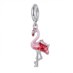 Ce charm pendentif met en scène un flamant rose élancé en argent sterling, rehaussé d’un dégradé d’émail rose qui donne du relief à son plumage et souligne sa silhouette gracieuse. Sa tête inclinée, son bec bicolore et son œil serti d’un petit cristal rose lui apportent une expression élégante et légèrement malicieuse, comme un oiseau en pleine parade. Une aile détaillée aux plumes sculptées et teintées de rose plus intense ajoute une touche tropicale raffinée, parfaite pour apporter soleil et légèreté à vo