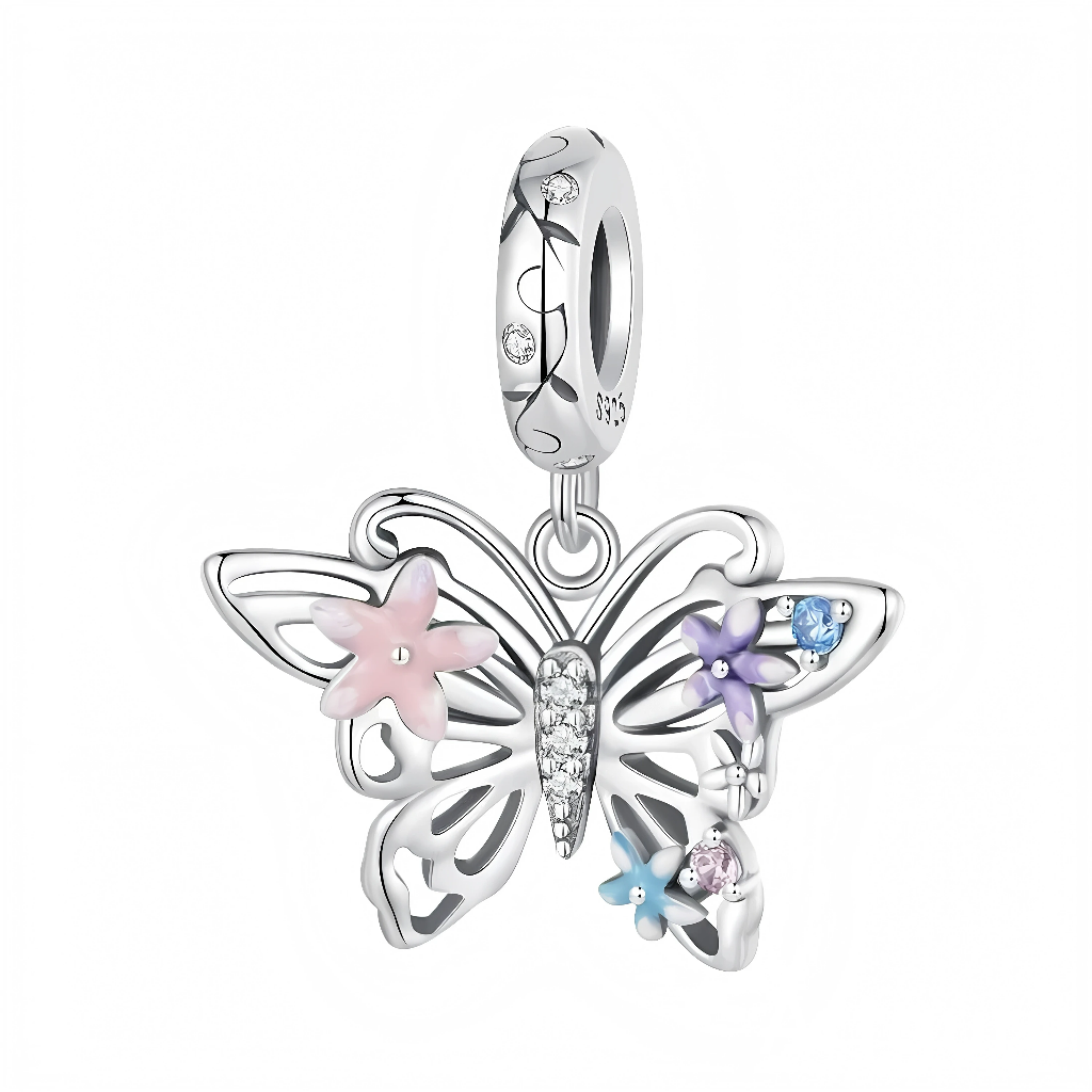 La bélière en argent 925 est gravée de fines volutes végétales et sertie de petits cristaux ronds, d’où pend un papillon aux ailes ajourées soulignées de courbes douces. Trois fleurs émaillées rose, lavande et bleu ciel ornent les ailes avec de petites pierres au centre, tandis que le corps du papillon est pavé de zircons clairs qui apportent de la brillance.