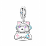 La bélière en argent 925 est décorée d’un petit cœur serti d’un cristal bleu, d’où pend un chat stylisé aux yeux violets scintillants, oreilles rosées et gros casque bleu clair. Entre ses pattes, le chat tient une manette de jeu avec croix directionnelle rose et boutons turquoise, rappelant l’univers coloré du gaming.
