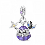 Ce charm pendentif en argent 925 représente un hibou nocturne au corps bombé violet, dont les plumes sont recouvertes d’un émail lumineux qui brille dans le noir après exposition à la lumière. Autour de lui, une étoile sertie de zircons clairs et d’un cristal jaune, ainsi qu’un croissant de lune avec chauve-souris noire incrusté de pierres bleues, renforcent l’atmosphère magique du ciel de nuit.