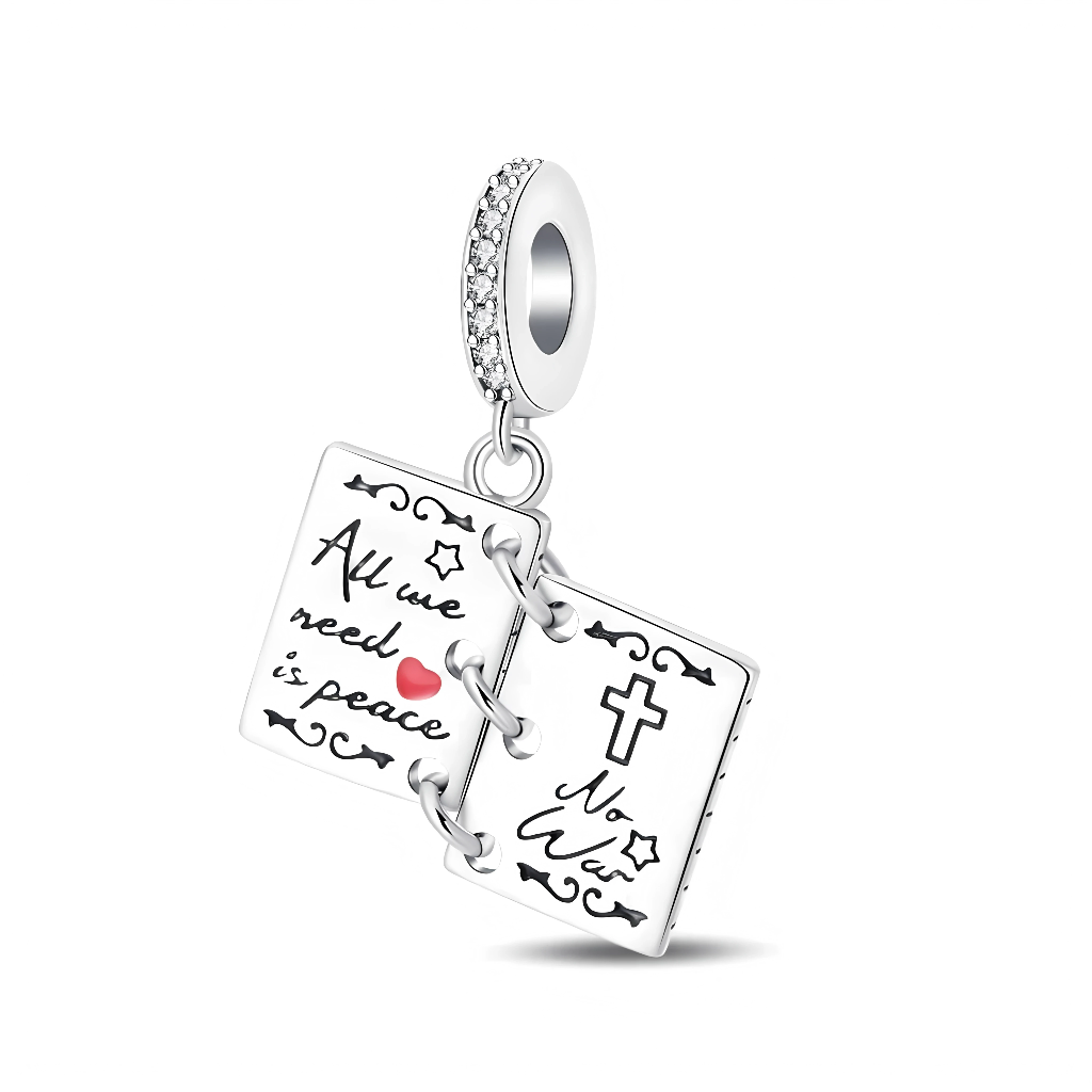 Ce charm en forme de petit livre ouvert en argent 925 présente deux pages articulées reliées par de petits anneaux, décorées de symboles de paix, d’un cœur rose et d’un motif de croix stylisée. La bélière sertie de cristaux clairs ajoute une touche lumineuse et élégante, idéale pour porter au poignet un message d’amour, d’espoir et de refus de la violence.