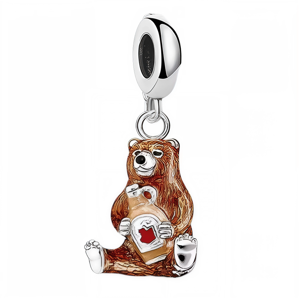 Ce charm attendrissant met en scène un ours assis, tenant contre lui une bouteille de sirop d’érable ornée d’une grande feuille rouge. Les détails en émail marron, blanc et rouge mettent en valeur la gourmandise et l’emblème iconique du Canada. Ce bijou est idéal comme clin d’œil aux traditions canadiennes, à l’amour des forêts et aux plaisirs sucrés. Parfait pour compléter un bracelet à thème voyage, nature ou pour offrir un souvenir inoubliable d’Amérique du Nord.

Caractéristiques
Matière : Argent 925, é