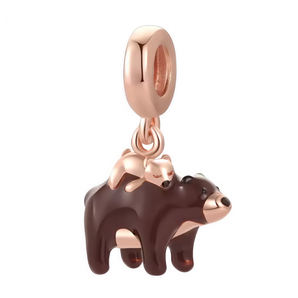Ce charm capture une scène attendrissante: un grand ours brun marche calmement tandis que son ourson, aux finitions or rose, se blottit sur son dos. Les volumes doux, le museau contrasté et l’émail chocolat donnent un rendu chaleureux, idéal pour célébrer la famille, la naissance ou un lien protecteur. La bélière lisse en plaqué or rose assure une finition élégante et intemporelle.