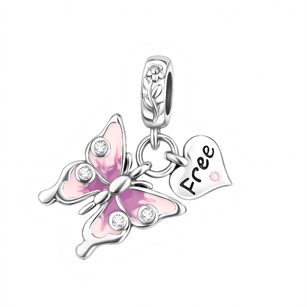 Le papillon est recouvert d’un émail rose dégradé et orné de petits zircons transparents sur les ailes, ce qui lui donne un éclat délicat à chaque mouvement du poignet. À côté, un cœur argenté porte l’inscription « Free » et une petite pierre rose en bas, comme un mantra discret à garder sur soi. La bélière est décorée d’un motif de tige et de fleur gravées, renforçant le thème nature et renouveau.