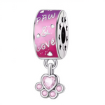 Ce charm exprime la passion pour nos compagnons à quatre pattes : sur le cylindre laqué d’un rose vif sont gravés des petits cœurs, l’inscription « Paw et&amp; Love » et des étoiles perforées sur la tranche. En dessous pend une ravissante patte ornée de pierres roses, dont un cristal central en forme de cœur. Idéal pour personnaliser le bracelet d’un amoureux des animaux ou marquer un joli message d’amitié fidèle.