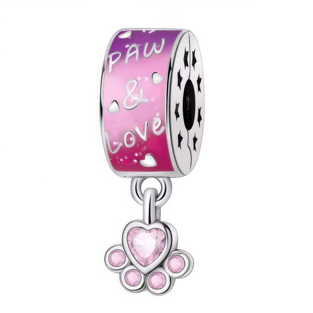 Ce charm exprime la passion pour nos compagnons à quatre pattes : sur le cylindre laqué d’un rose vif sont gravés des petits cœurs, l’inscription « Paw et&amp; Love » et des étoiles perforées sur la tranche. En dessous pend une ravissante patte ornée de pierres roses, dont un cristal central en forme de cœur. Idéal pour personnaliser le bracelet d’un amoureux des animaux ou marquer un joli message d’amitié fidèle.
