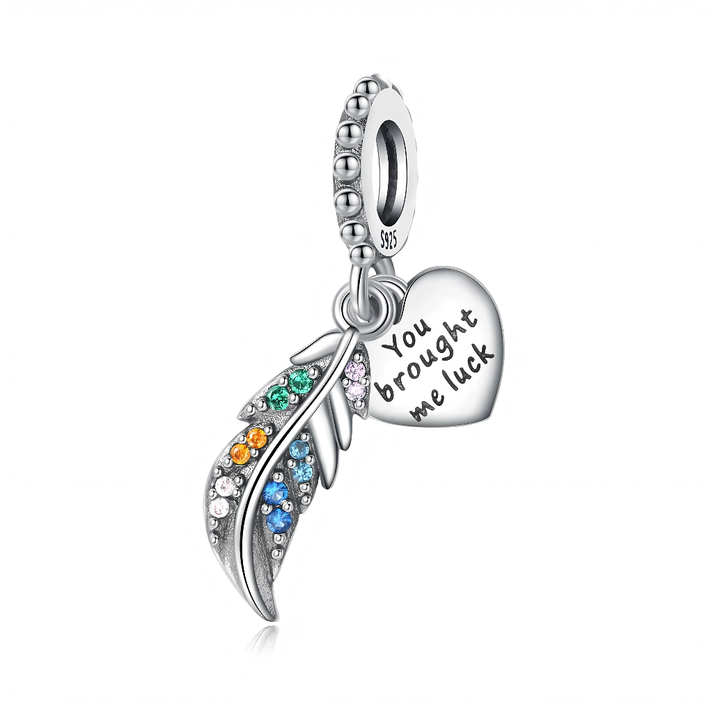 La bélière ronde texturée laisse pendre la plume, ornée de pierres scintillantes aux tons bleu, vert, orange et rose qui évoquent l’arc‑en‑ciel et la chance. Le cœur lisse ajoute une touche sentimentale, parfaite pour remercier une personne qui a été votre porte‑bonheur.etsy+2