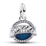 Apporte une touche d’évasion et de modernité à ton bracelet avec ce charm inspiré d’un pont et d’une vague bleue. Son design élégant associe l’architecture et l’univers marin, pour un rendu original, lumineux et plein de caractère. Un bijou raffiné et symbolique, parfait pour les amoureux du voyage, de la mer et des pièces uniques.

Caractéristiques :

-&nbsp;Matière : Argent 925.
-&nbsp;Design : Pont stylisé avec vague bleue et détails sertis de strass.
-&nbsp;Dimensions : Taille délicate et confortable à 