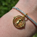 Voyagez dans le temps avec élégance grâce à ce pendentif inspiré du Retourneur de Temps. Fabriqué en argent sterling 925 et orné de détails brillants, ce pendentif capturera l’essence magique et mystérieuse de cet objet emblématique de l'univers de Harry Potter. Avec son design raffiné et ses incrustations scintillantes, ce pendentif est parfait pour les amateurs de la saga qui souhaitent ajouter une touche de mystère et de sophistication à leur collier ou bracelet.