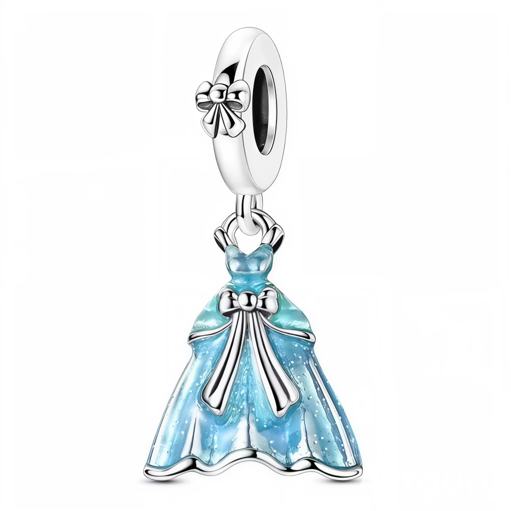 Ce charm capture l’élégance d’une robe de bal: le jupon ample est laqué d’un bleu glacé parsemé de paillettes, tandis que les rubans et bordures en argent poli accentuent le volume et la grâce du modèle. La bélière assortie est gravée d’un petit nœud pour un rappel raffiné. Parfait pour un thème Disney‑like, bal, mariage ou soirée, il apporte éclat et poésie à toute composition.