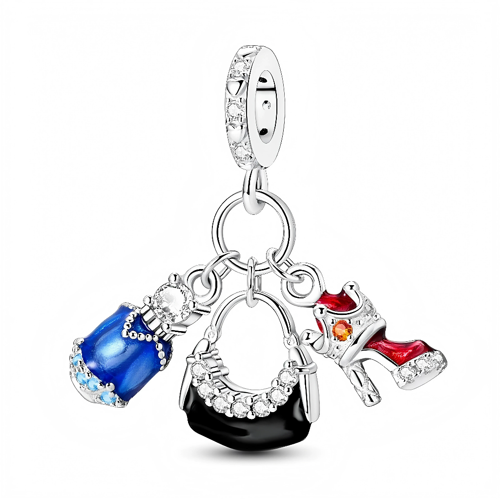 La bélière circulaire en argent 925 est pavée de petits zircons transparents tout autour, puis reliée à un anneau qui porte trois breloques mobiles. On y trouve une robe émaillée bleu brillant décorée de pierres claires, un sac à main noir rehaussé d’un arc de zircons scintillants, et une bottine‑escarpin rouge ornée d’un petit cristal orange et d’une semelle claire. L’ensemble évoque une tenue de soirée glamour, parfaite pour les passionnées de shopping et de mode.