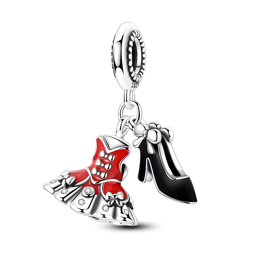La petite robe bustier rouge est décorée de nœuds argentés et de pierres claires qui évoquent des strass, tandis que la jupe patineuse est ponctuée de petits cabochons scintillants. L’escarpin noir verni, suspendu à côté, est souligné d’un nœud sur l’arrière, ce qui donne un ensemble glamour parfait pour un thème soirée, mode ou « lady in red »