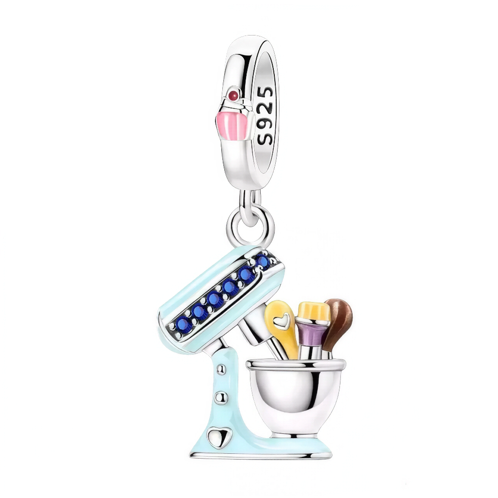 Ce pendentif capture l’ambiance d’un atelier de pâtisserie avec un design soigné et ultra-lumineux. Le corps bleu pastel, souligné d’une rangée de cristaux, contraste avec le bol poli miroir qui accueille fouet, spatule et cuillère aux émaux colorés. La bélière marquée S925 et ornée d’un mini cupcake rose ajoute une touche délicieusement fun. Parfait pour célébrer la passion du fait‑maison, il apporte chaleur et créativité à un bracelet ou un collier.