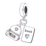 Exprimez votre amour pour l’apprentissage et l’aventure avec ce charm pendentif double en argent 925. Finement travaillé, il présente un petit sac à dos suspendu aux côtés d’un livre ouvert, gravé du mot "Book". L’ensemble crée une composition équilibrée, à la fois délicate et évocatrice. Que ce soit pour célébrer une rentrée, un voyage d’étude ou votre passion pour la lecture, ce bijou symbolique est le compagnon parfait de votre bracelet.
